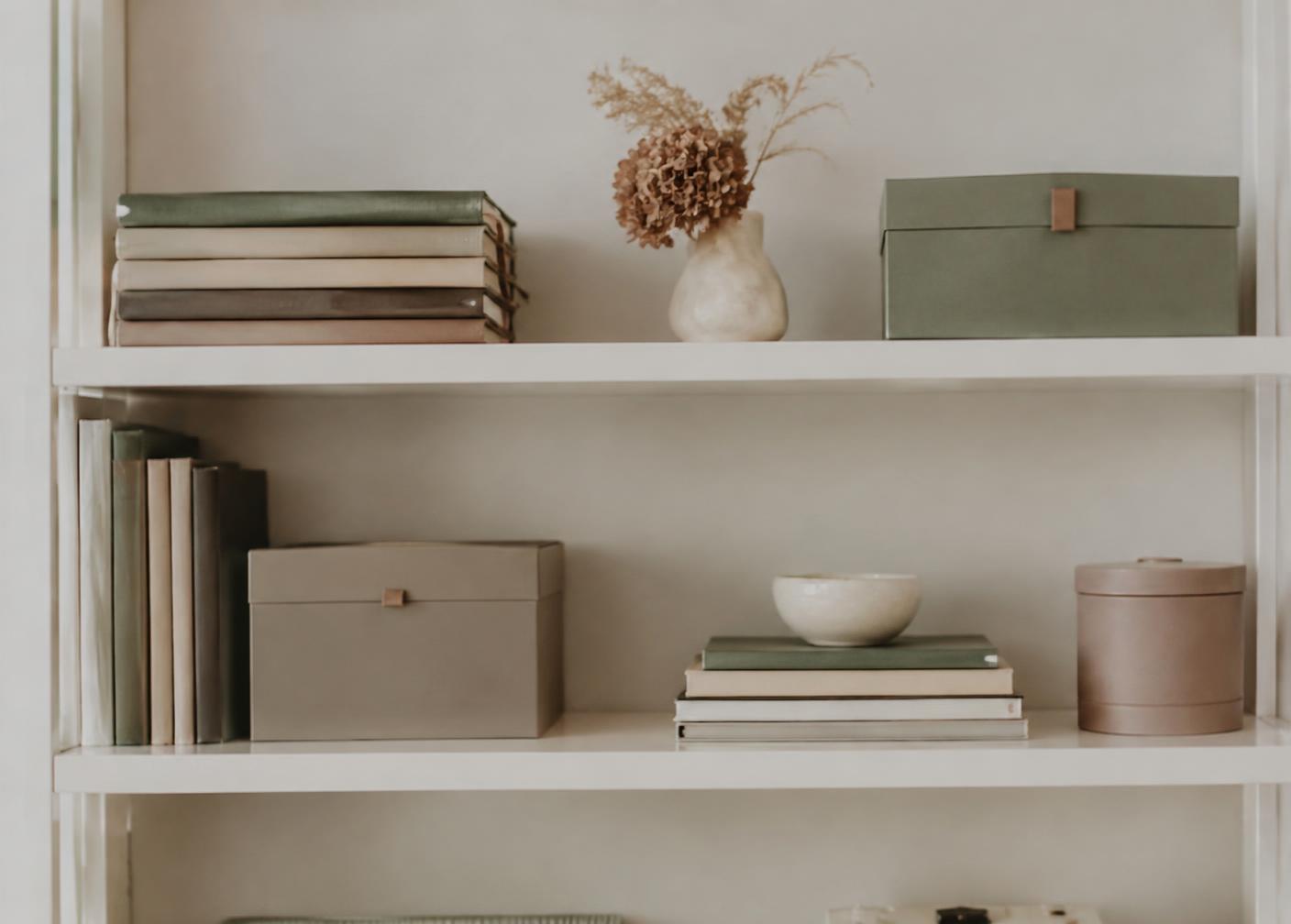 Neatly organized shelf with notebooks and storage boxes